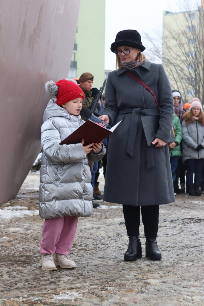Dziewczynka czyta list byłej więźniarki obozu