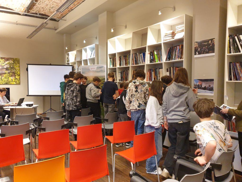 Uczniowie przeglądają komiksy dostępne  w  bibliotece francuskiej Alliance Française.