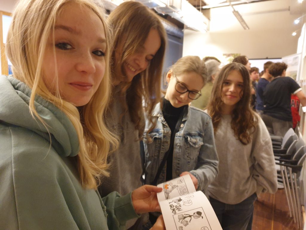 Dziewczynki przeglądają komiksy dostępne  w  bibliotece francuskiej Alliance Française.