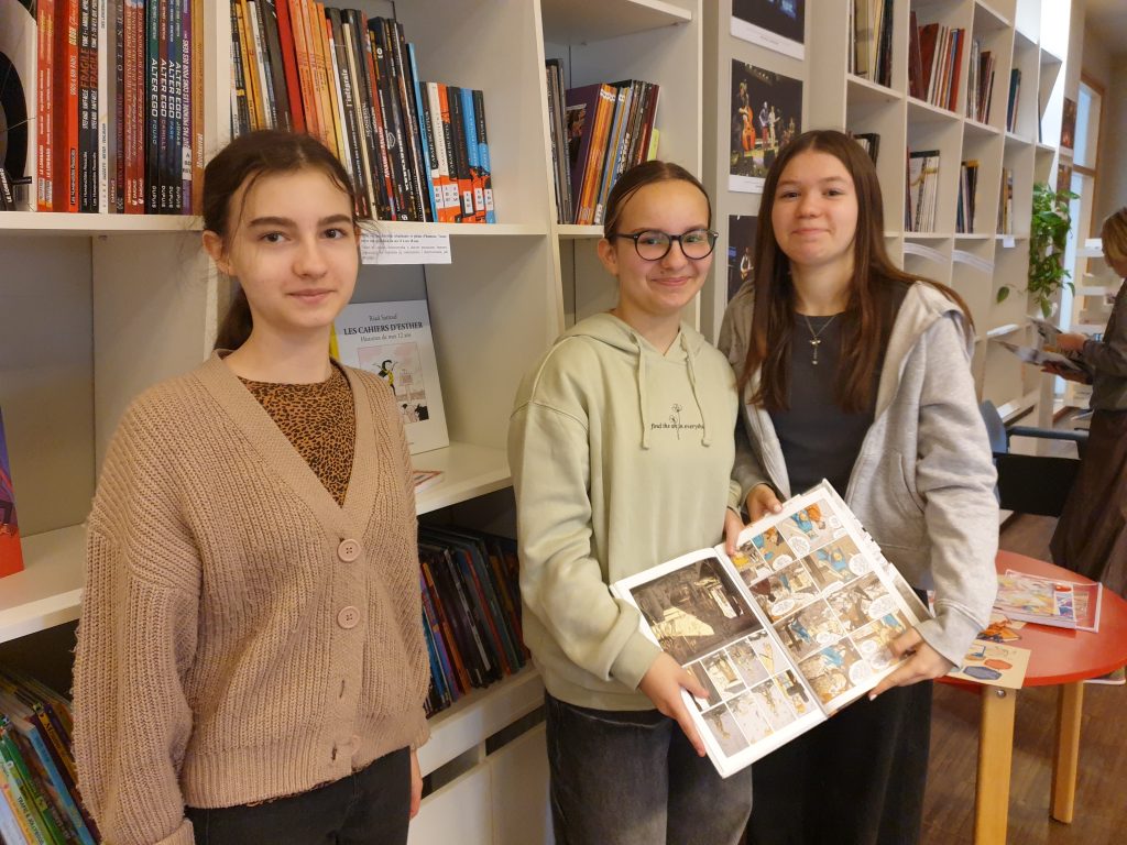 Dziewczynki przeglądają komiksy dostępne  w  bibliotece francuskiej Alliance Française.